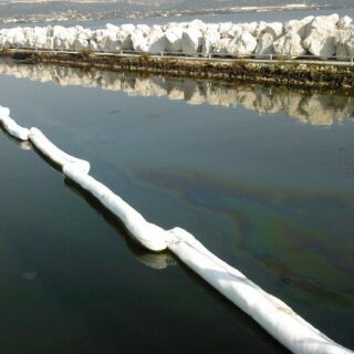 Déploiement d'un barrage flottant antipollution pour bloquer une nappe d'huile sur l'eau